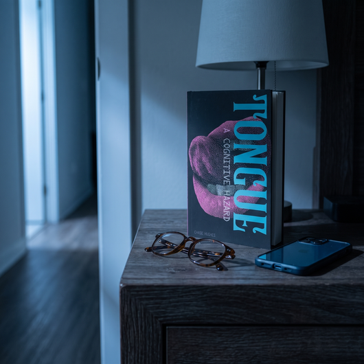 TONGUE: A Cognitive Hazard standing on a nightstand at night